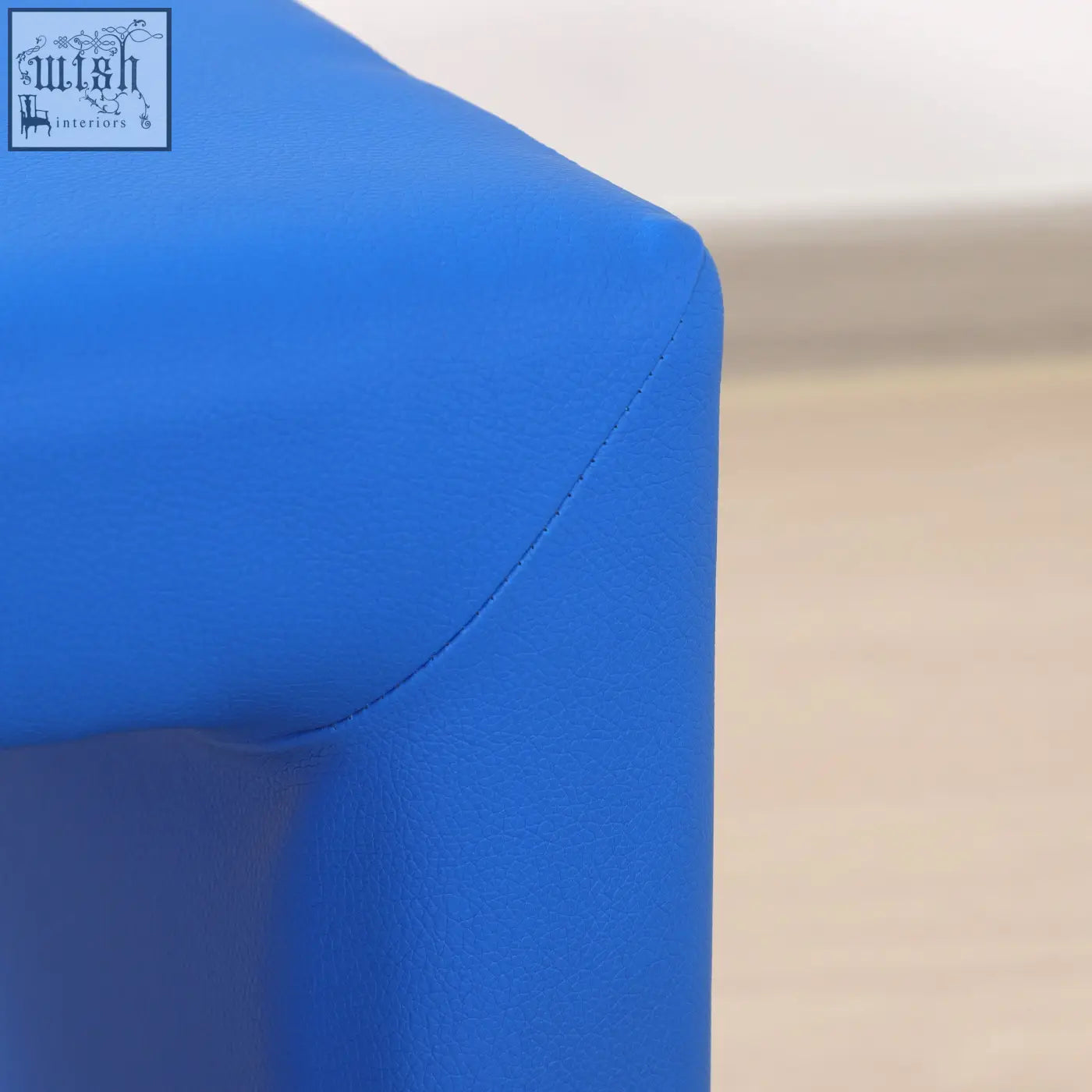 Blue soft-textured upholstered toddler sofa chair with clean stitching and wooden frame for playroom use