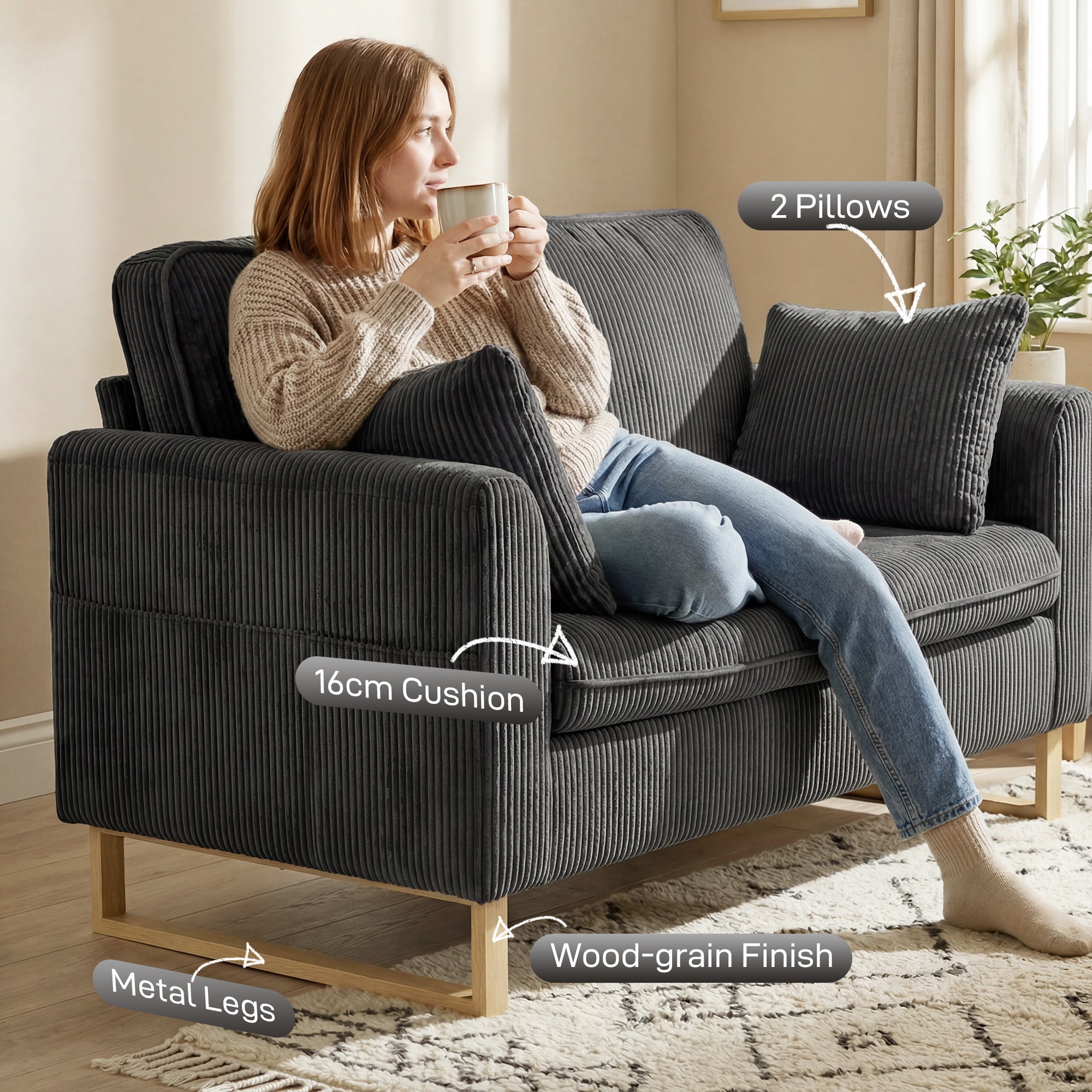 Dark grey corduroy seater sofa with wooden legs and metal feet featuring spring cushions and two pillows