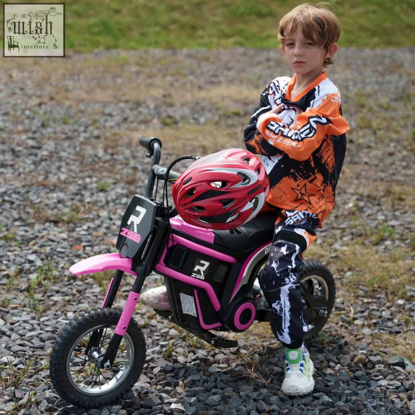 Pink and black HOMCOM 24V electric motorbike with two adjustable speeds and red helmet on seat for kids riding fun