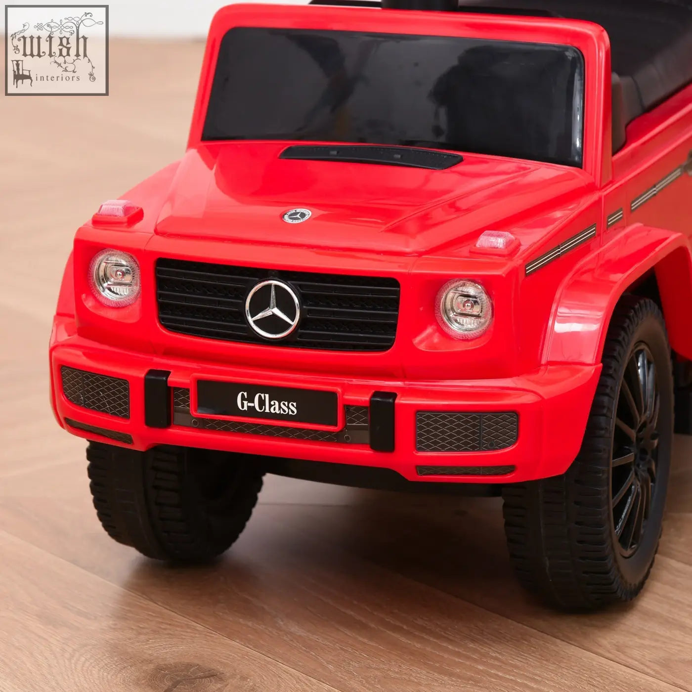 Red plastic mercedes-benz g-class electric ride-on sliding car with black tires and moving steering wheel for toddlers