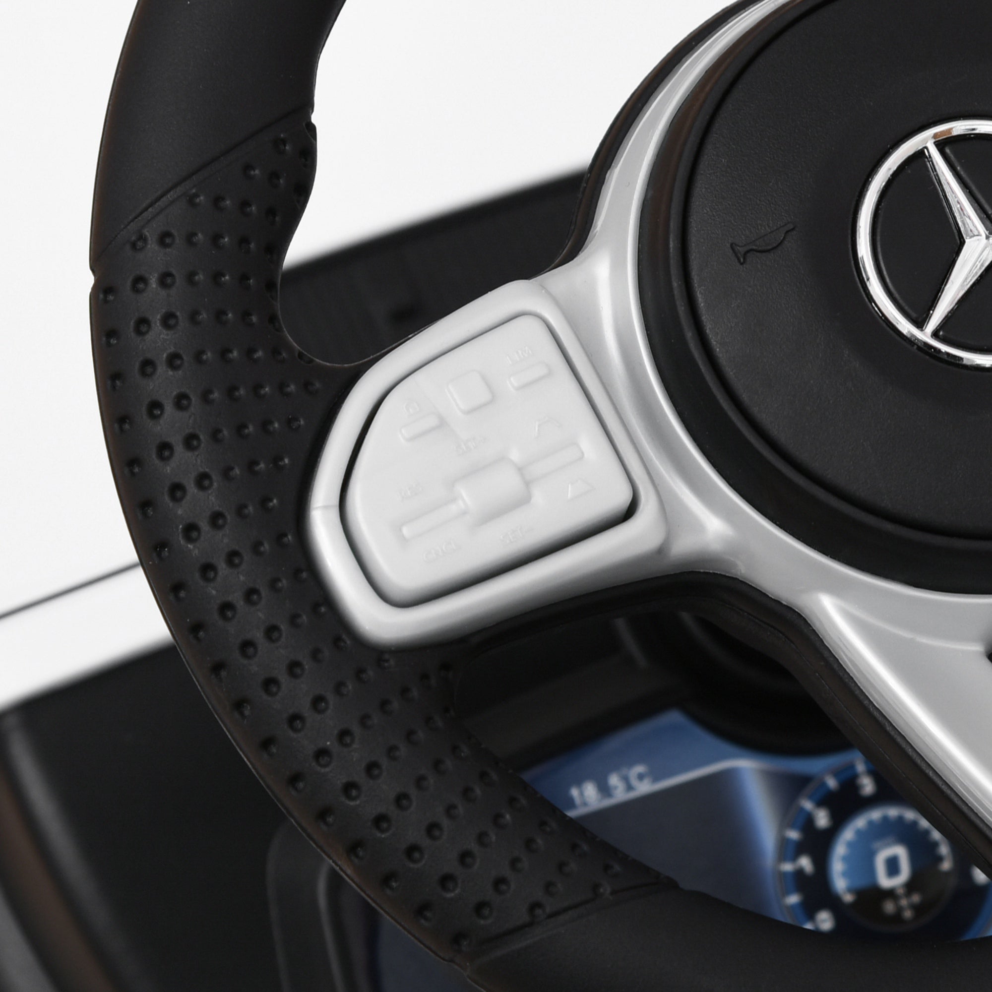 Black perforated steering wheel with silver accents and mercedes-benz logo on white homcom 3 in 1 kids ride on car with foot-to-floor design and under-seat storage