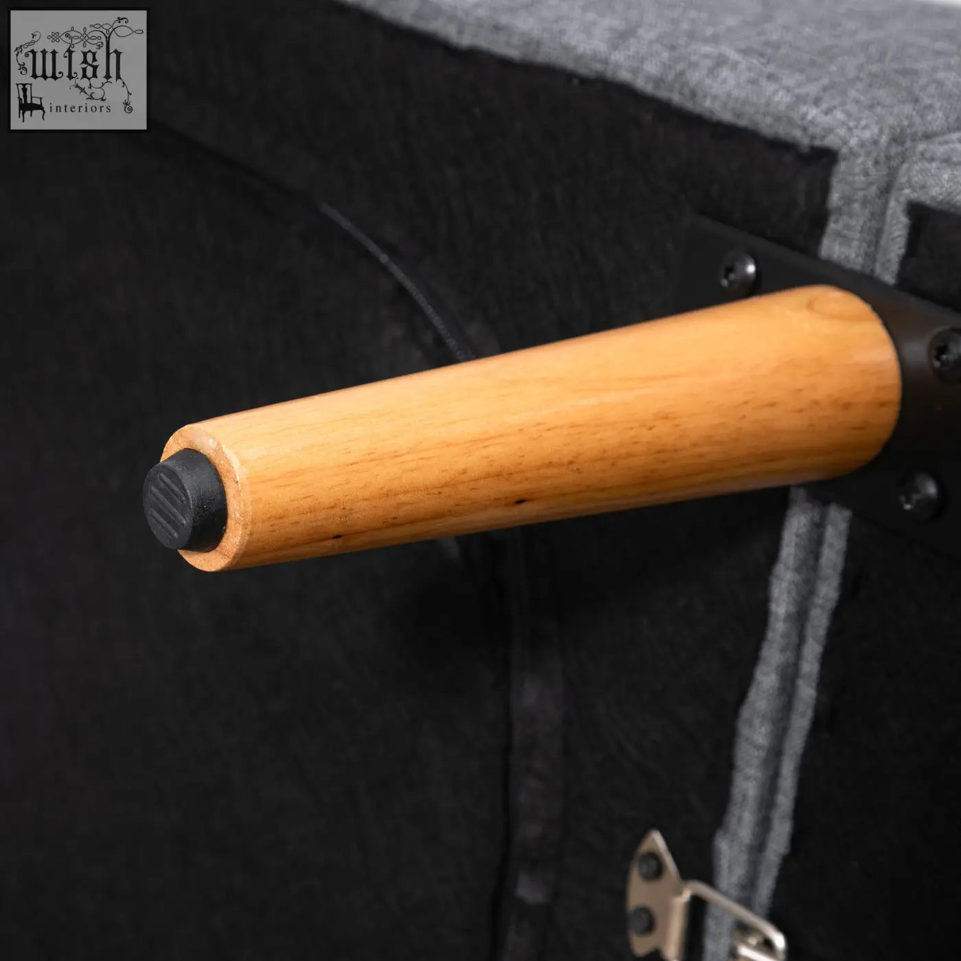 Light brown wooden leg with black rubber cap on grey linen fabric sofa bed with six wooden legs for living room use