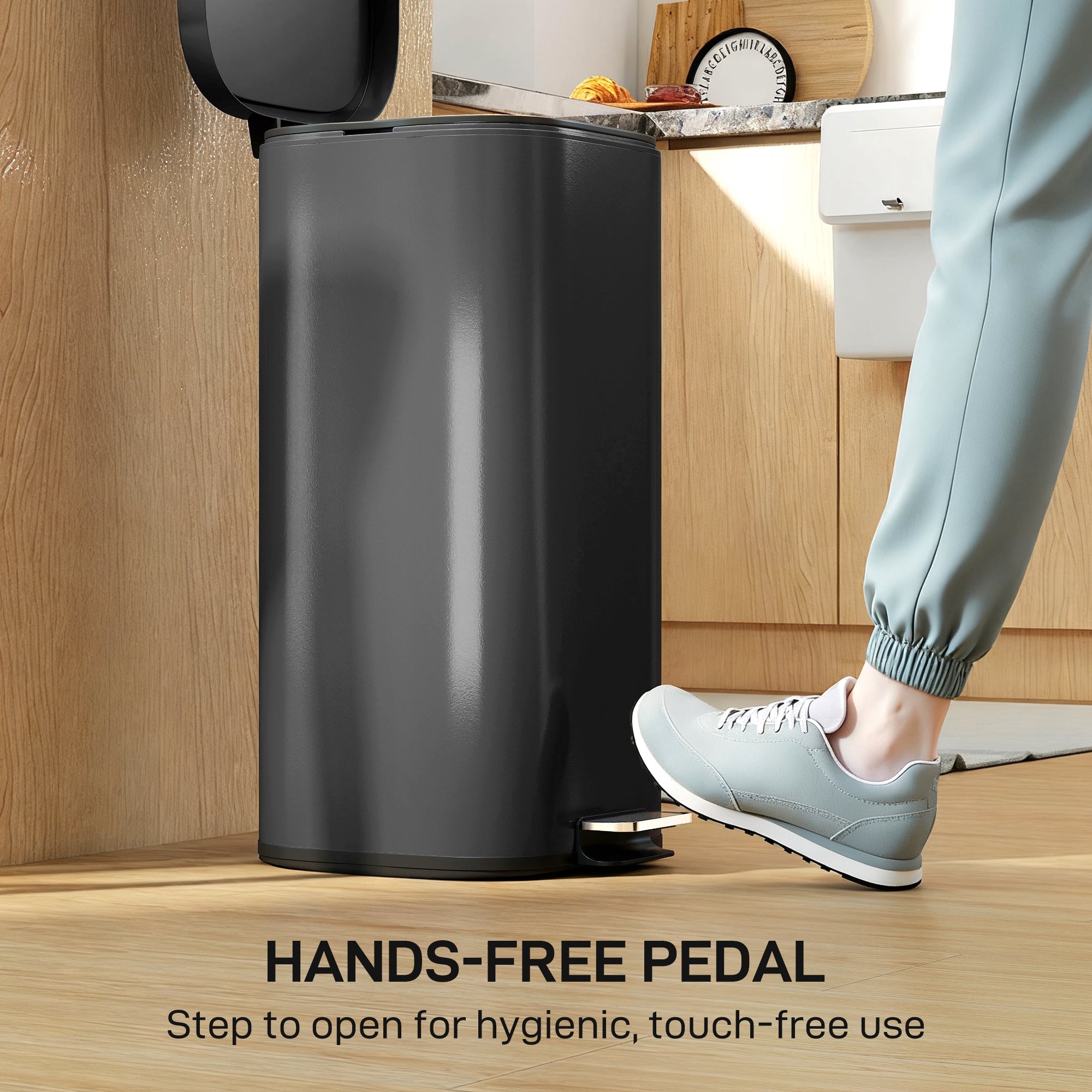Black cylindrical kitchen bin with metal design and soft-close lid featuring a pedal for hands-free use
