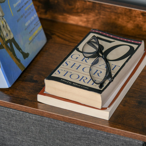Black homcom storage chest with two small drawers and two large drawers topped with black-framed reading glasses