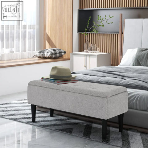 Gray upholstered storage ottoman with wooden legs and tufted top perfect for small furnishings and bedroom use