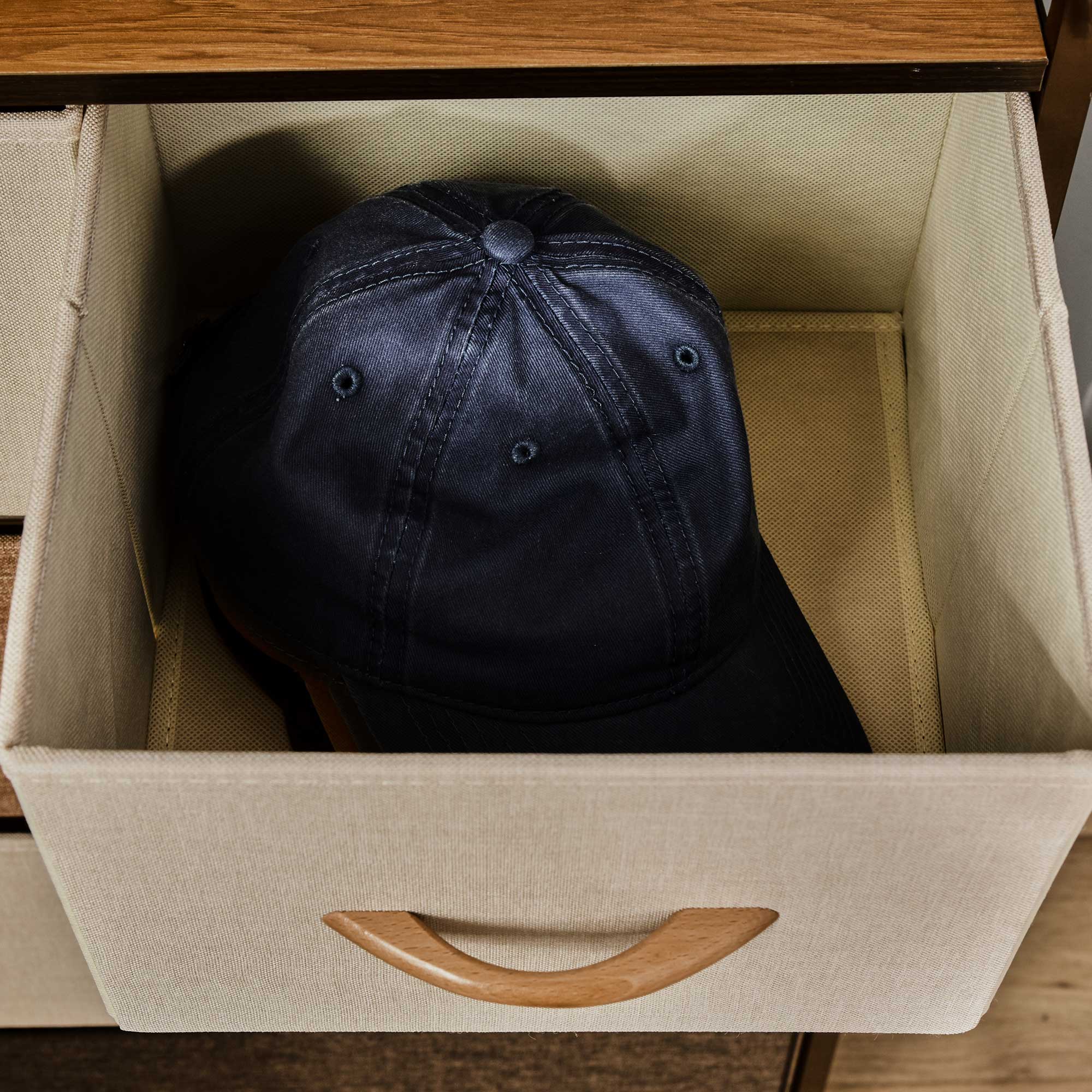 Dark blue denim baseball cap with visible stitching and button details paired with homcom 5-drawer dresser tower with steel frame and wooden top