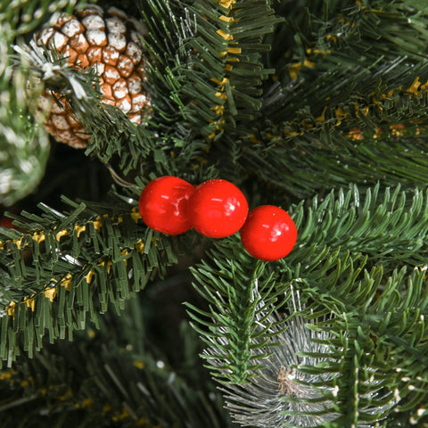 Three glossy red berries nestled on green artificial pine branches of a christmas tree with white pinecones