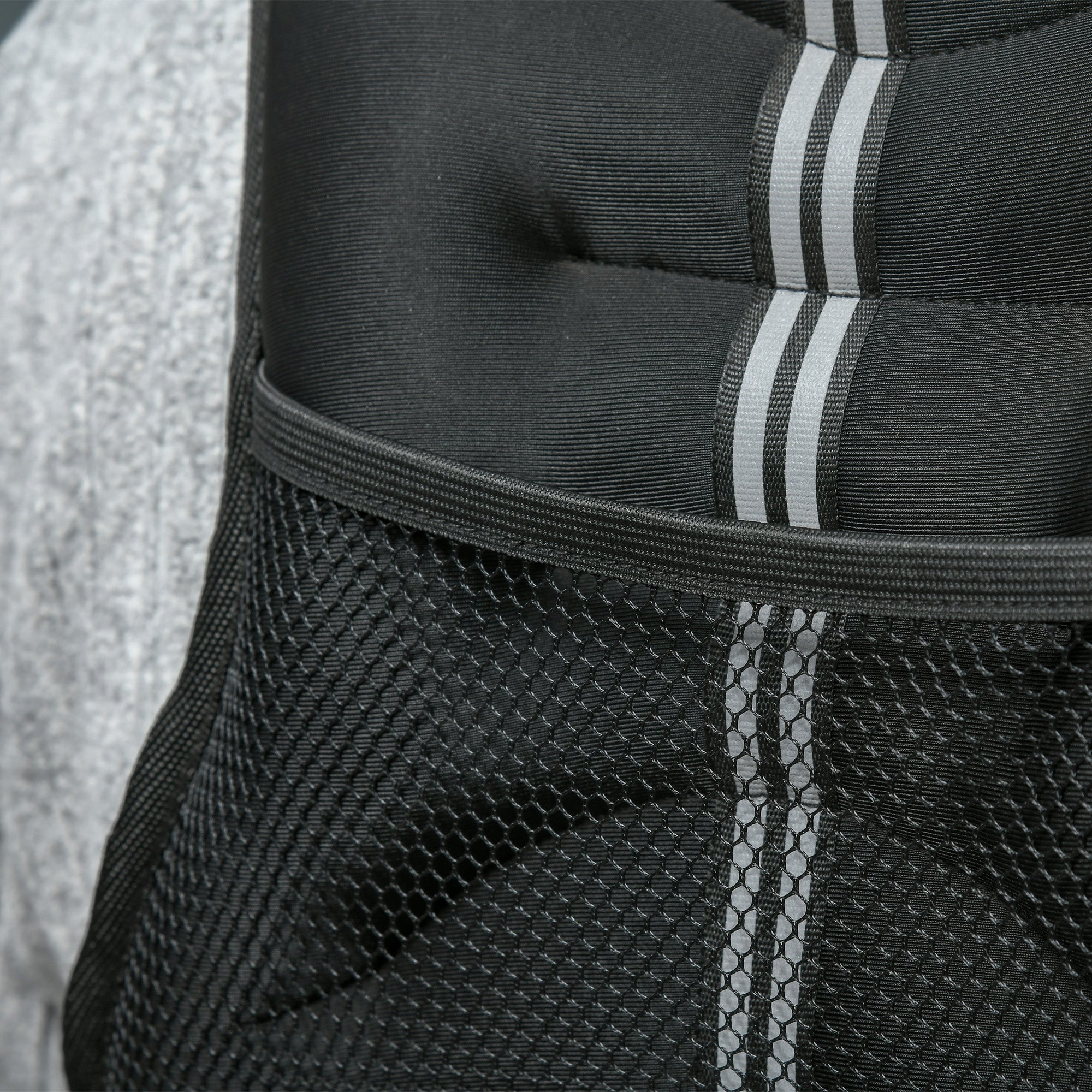 Black adidas backpack with three white stripes and mesh side pocket shown with homcom running weight vest in oxford fabric