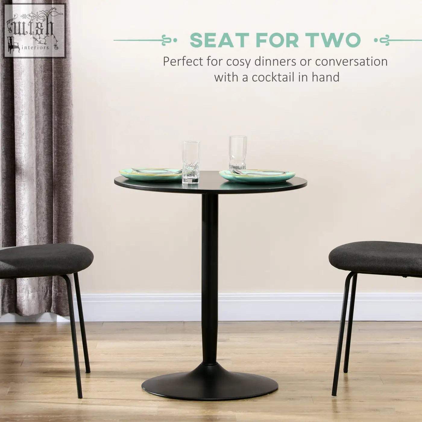 Black round table with powder coated steel frame and pedestal base set for two with teal plates and glasses