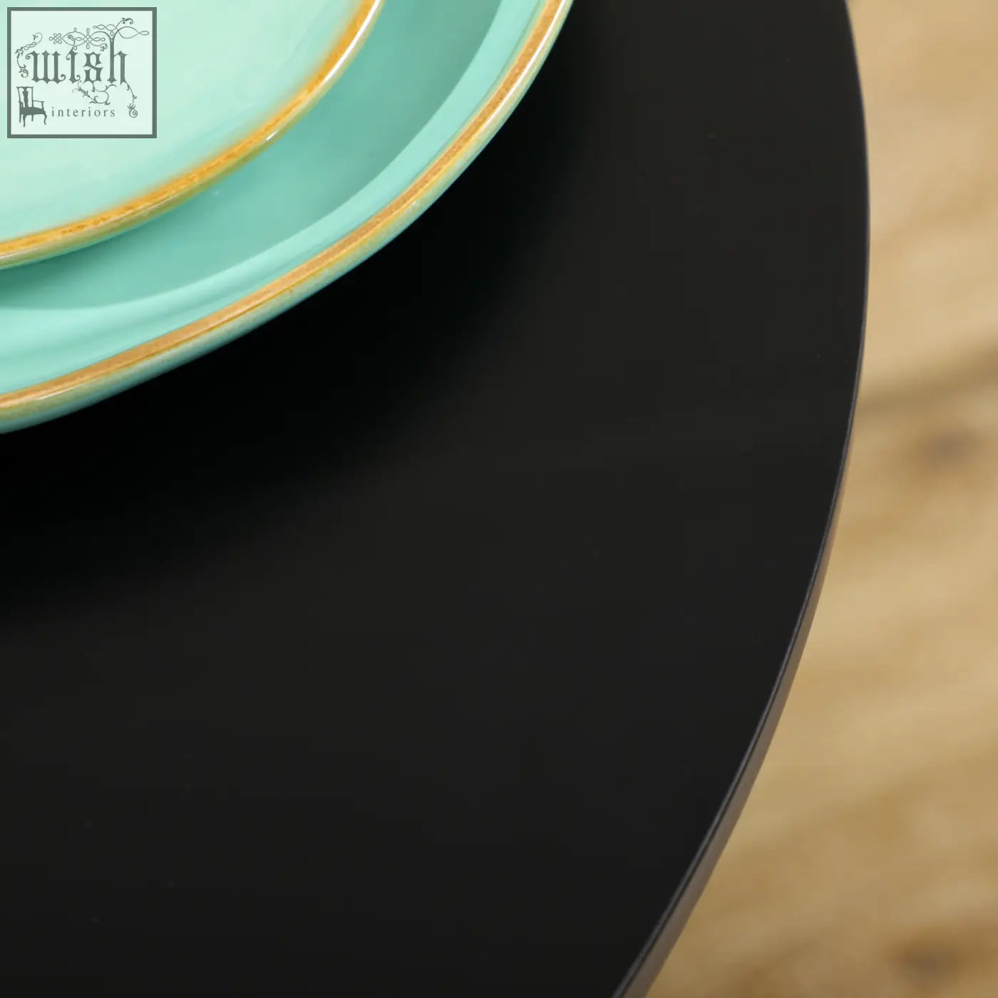 Turquoise ceramic plates with gold rims on a black homcom round table with powder coated steel frame