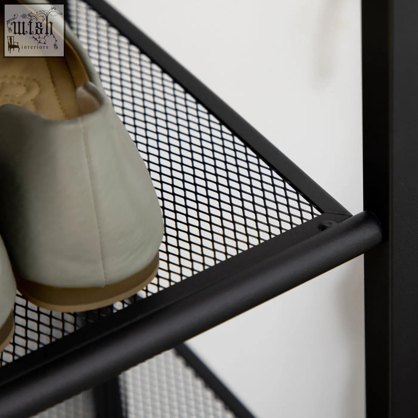 Black metal mesh shoe rack with light gray slip-on shoe featuring a seven-tier design and narrow design for easy storage