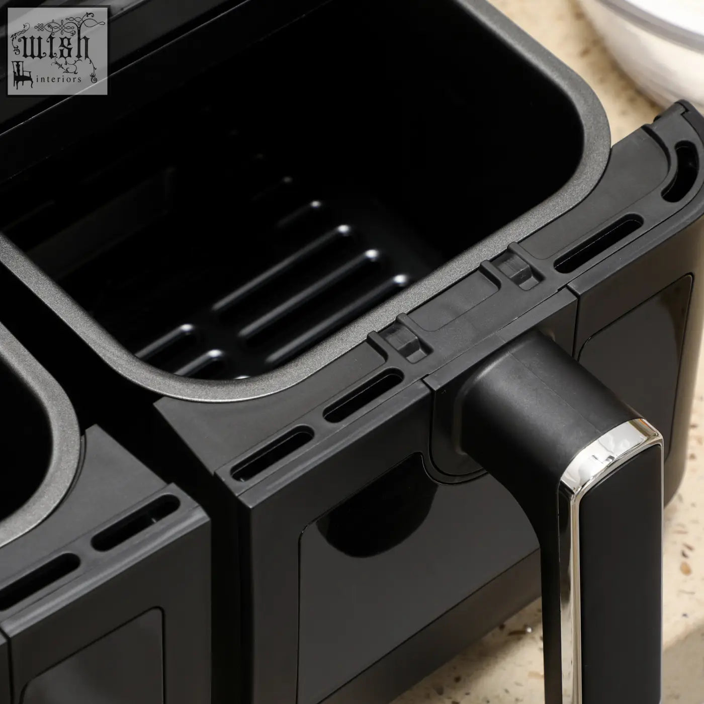 Black plastic air fryer basket with ridged interior and silver-accented handle for homcom 8l dual basket air fryer