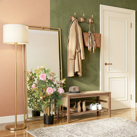 Gold-framed floor mirror with a tall stand and white lampshade next to a pink artificial rose tree set for indoor decor