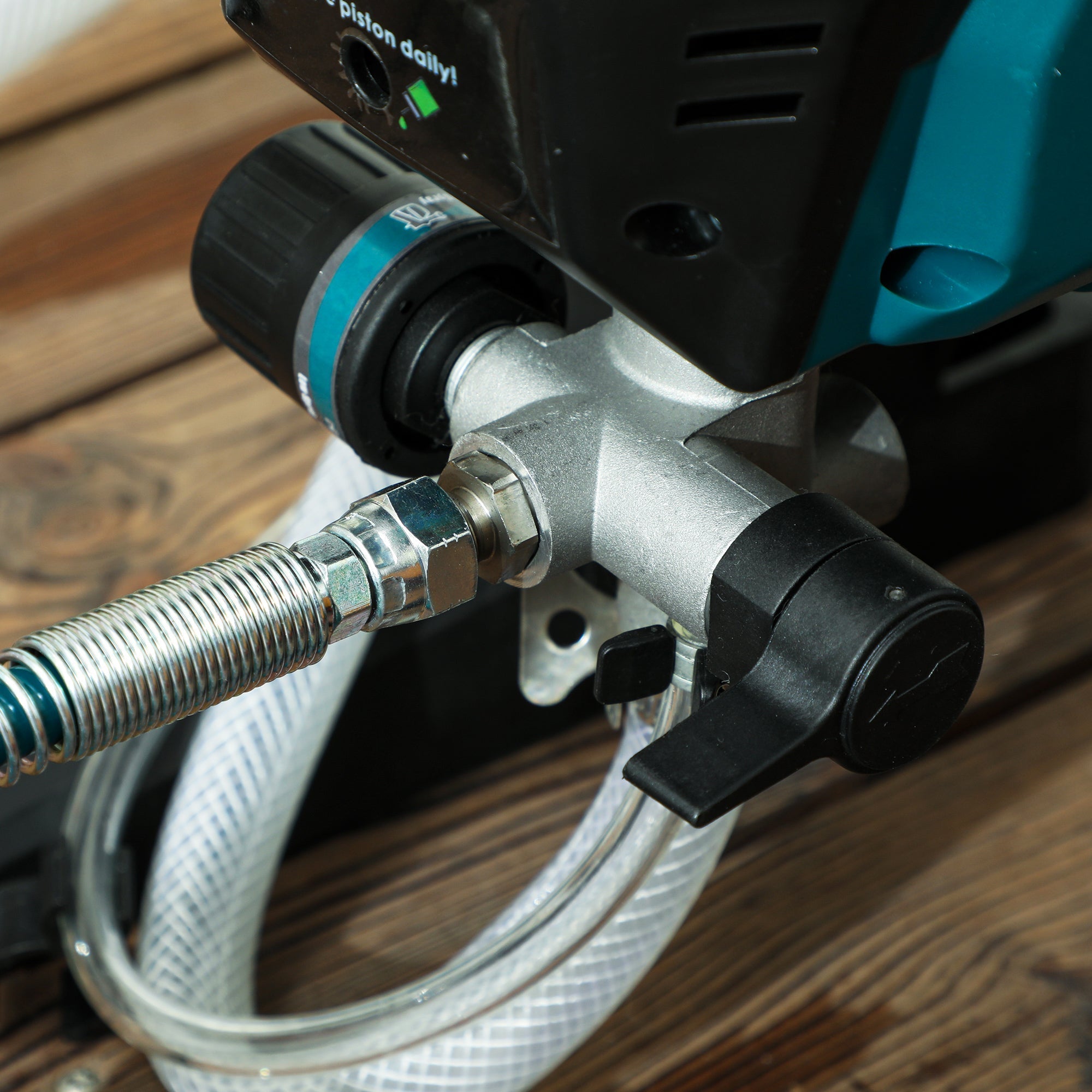 Teal and black makita pressure washer with silver metal hose connection and white braided tubing for homcom airless paint sprayer use