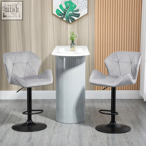 Gray upholstered bar stools with velvet-feel upholstery, round base, and metal frame footrest for kitchen seating