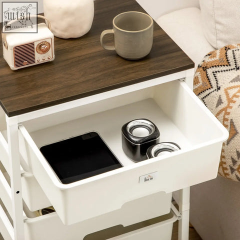 White plastic storage cart with dark wood top and steel frame features six drawers, one open with speakers and tablet inside