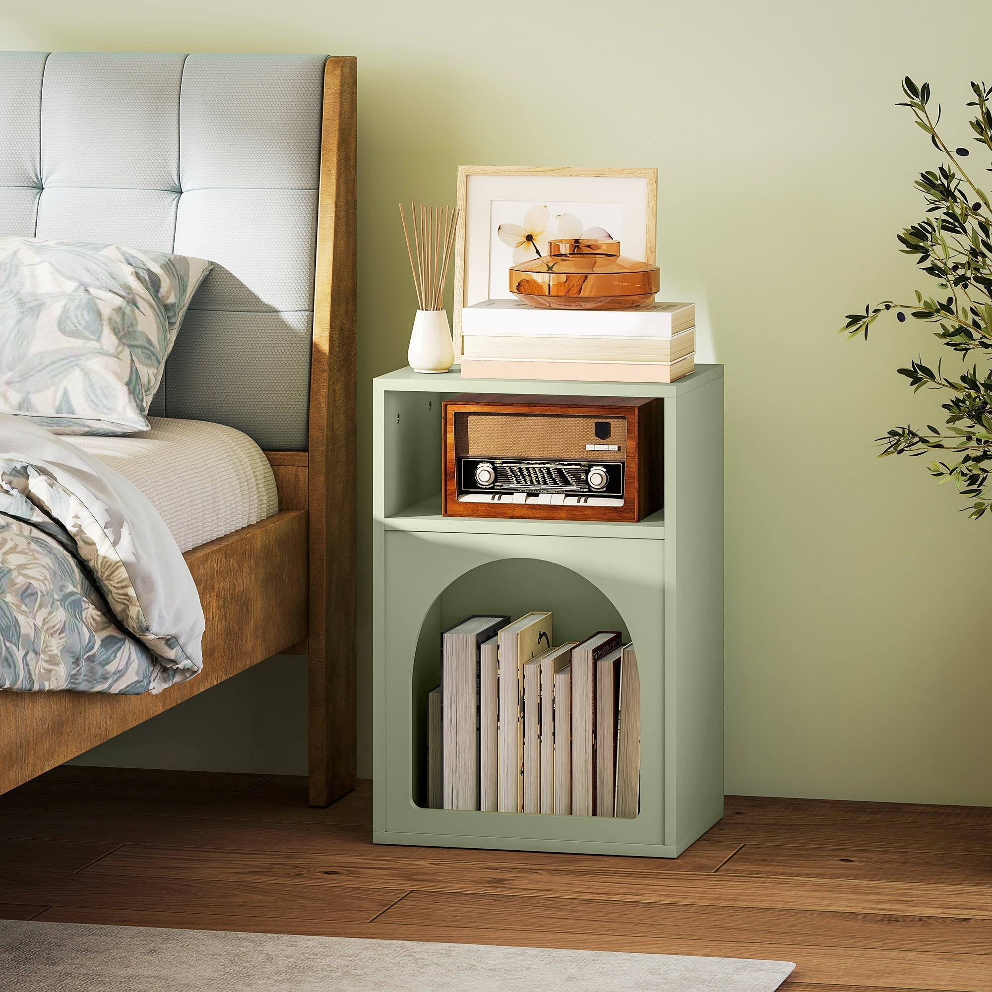 Mint green bedside table with two open compartments and arched lower shelf holding a wooden radio