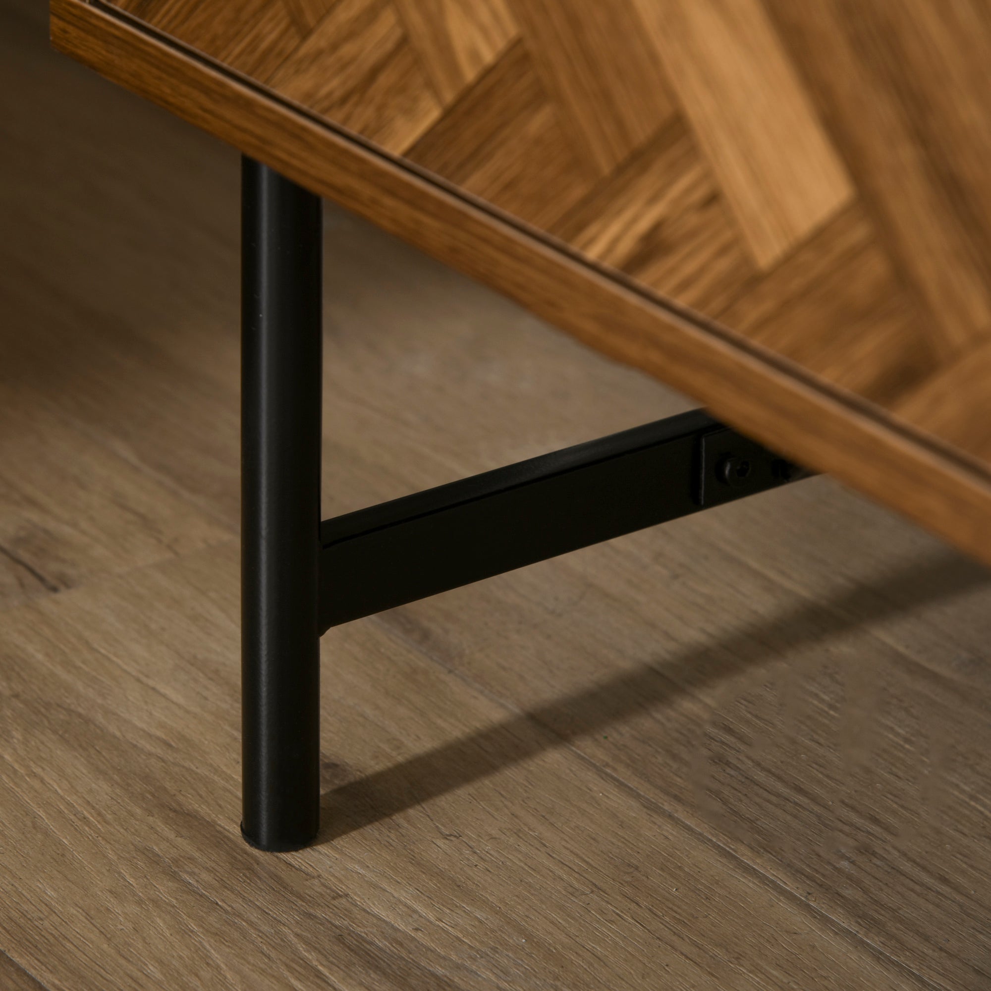 Black metal leg with sleek cylindrical design supporting walnut brown particle board bedside table with two drawers