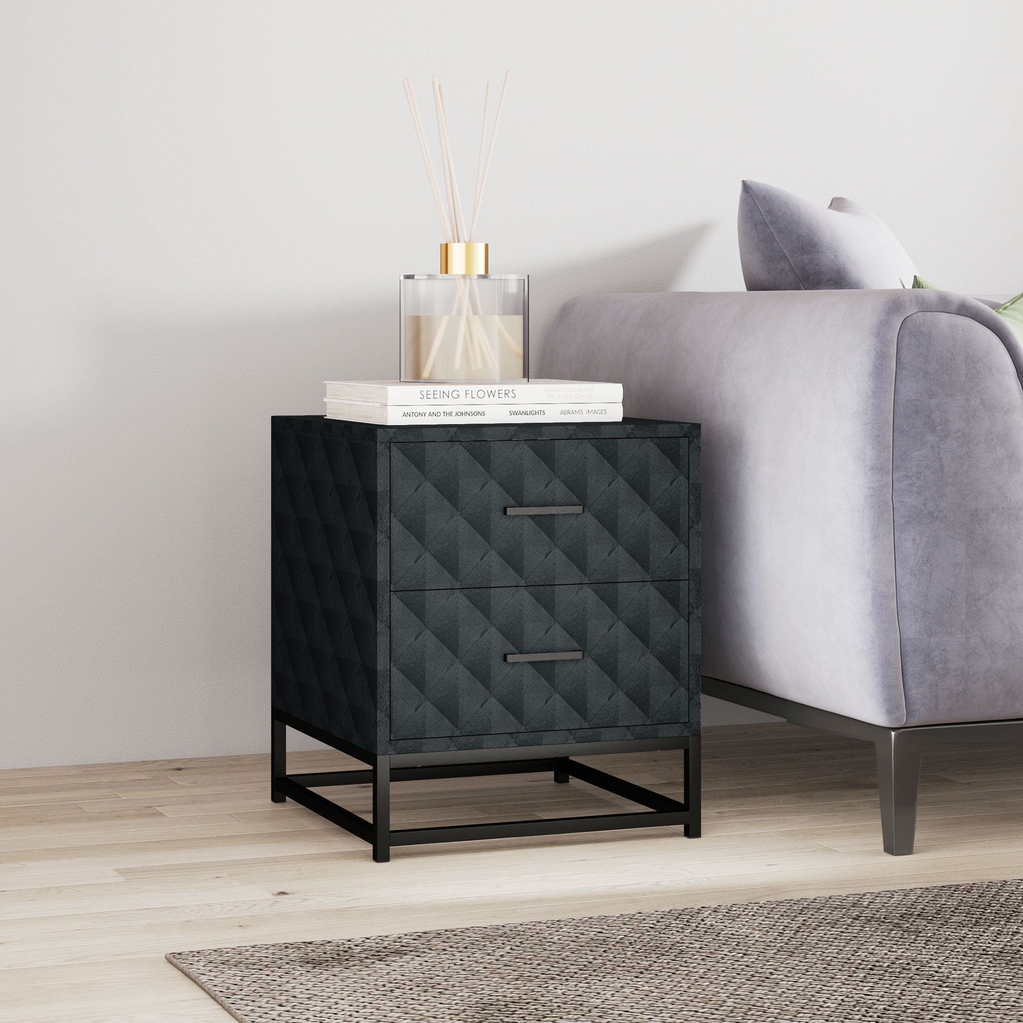 Black diamond-quilted bedside table with two drawers and sleek black steel frame for bedroom or living room storage