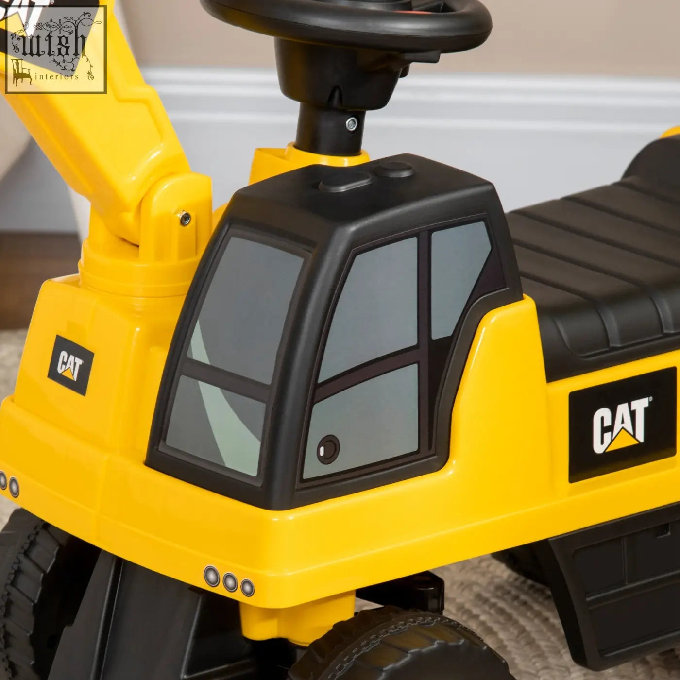 Yellow and black cat licensed construction ride-on excavator toy with plastic cab steering wheel and textured seat for toddlers