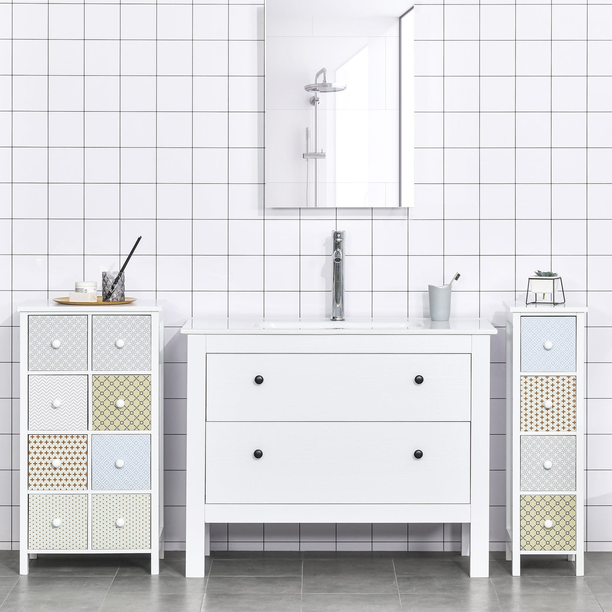 White bathroom vanity with two drawers and black knobs with matching patterned storage units and anti-tipping straps