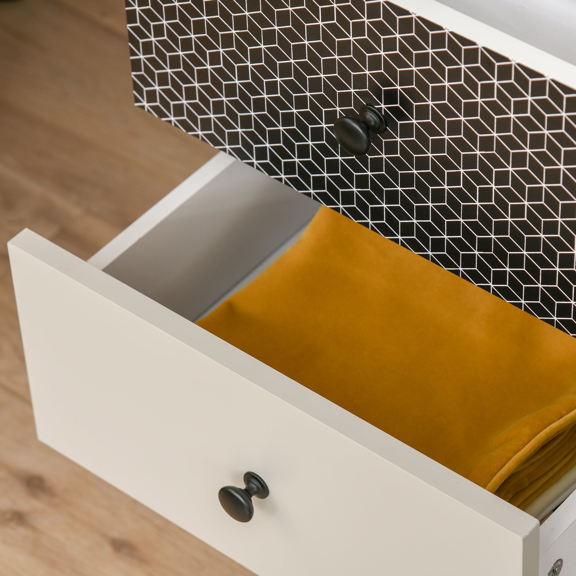 White HOMCOM chest of drawers with black knobs and geometric interior holding mustard fabric for living room use
