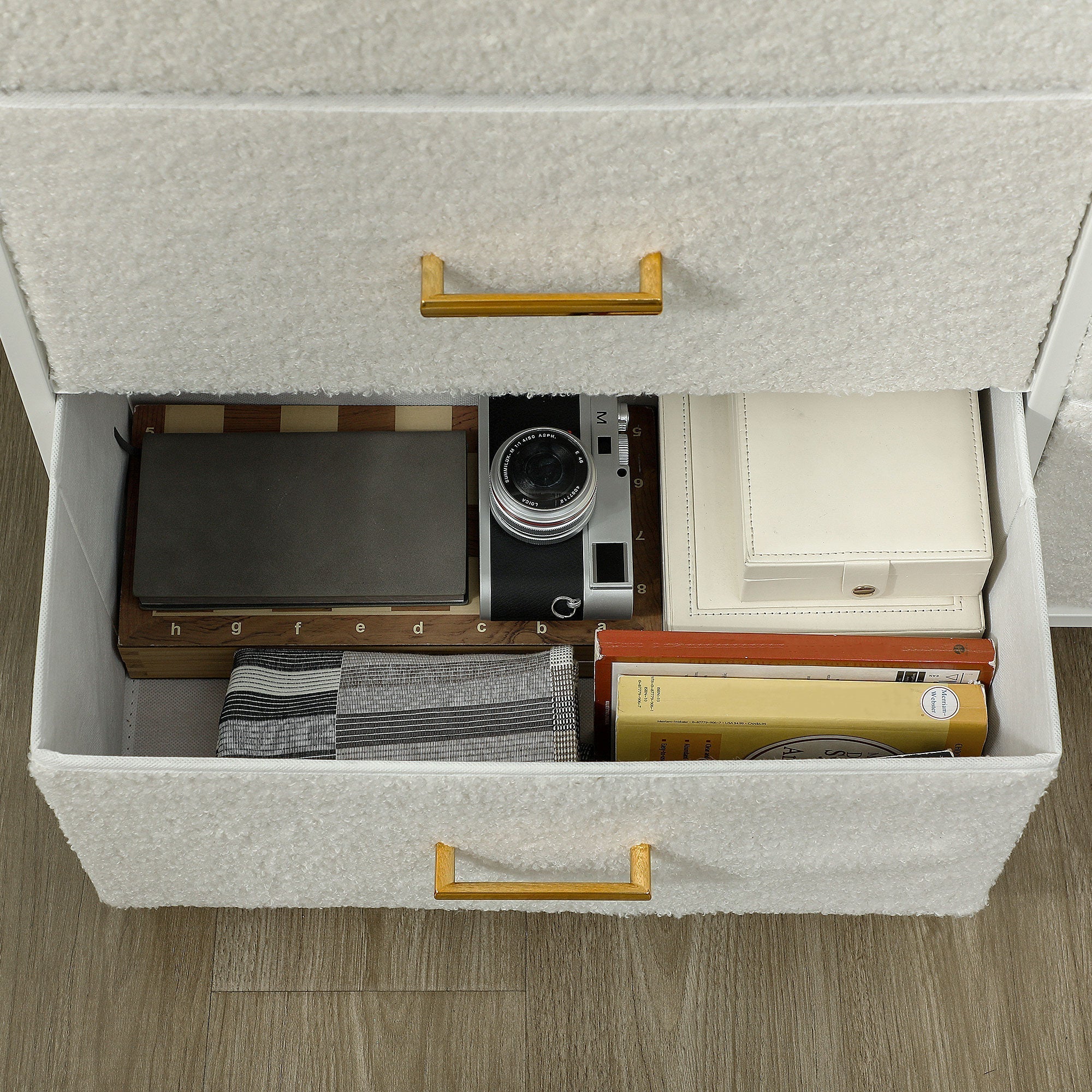 Silver and black vintage camera resting inside an open fabric drawer of a cream white HOMCOM chest with boucle fabric drawers and adjustable feet pads