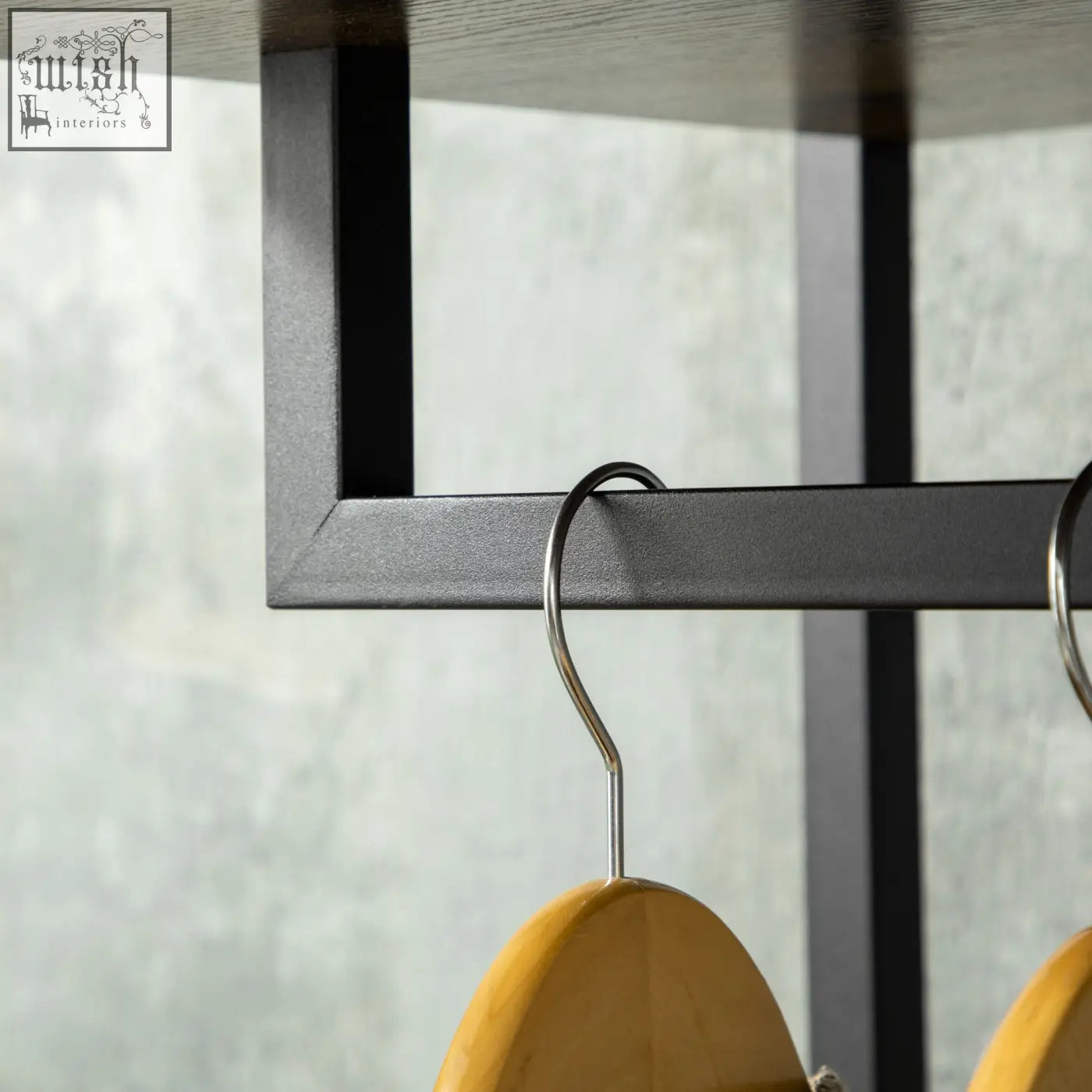 A light brown wooden hanger with a sleek metal hook on the homcom clothes rail with fabric storage drawers in rustic brown and grey