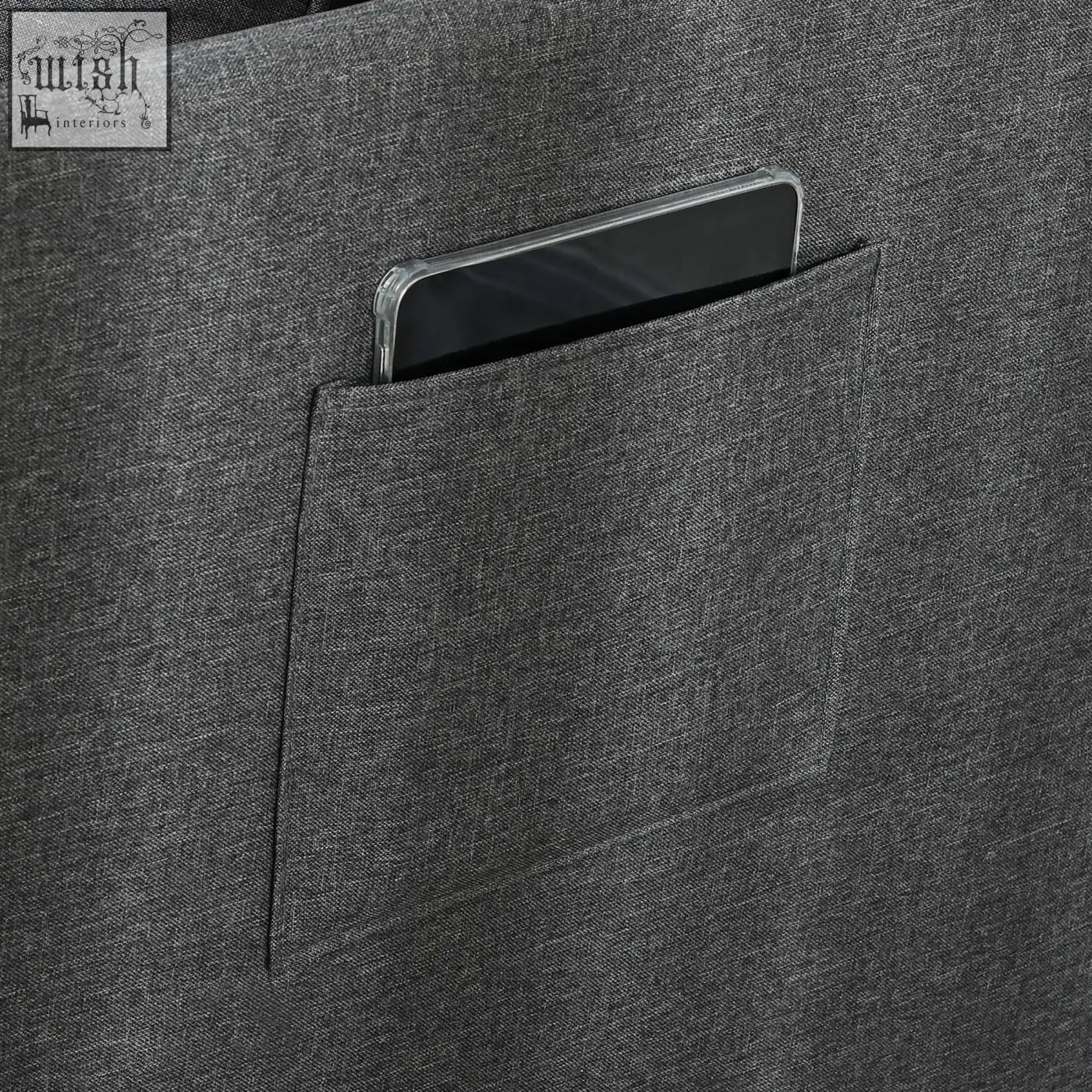 Dark gray textured fabric tote bag with front pocket holding phone next to grey homcom chair bed with thick padded seat