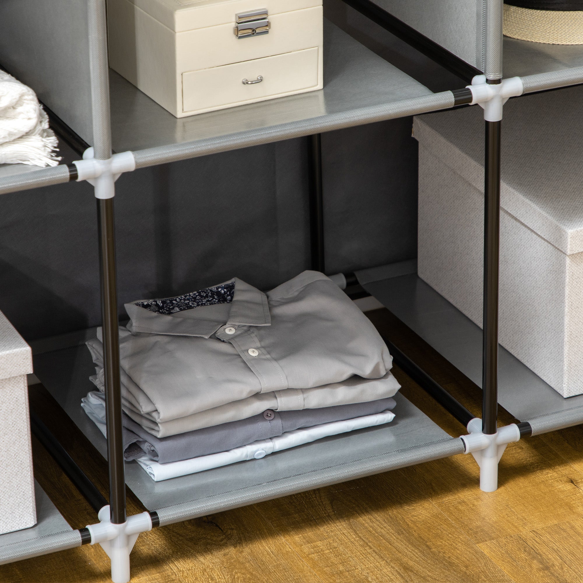 Gray fabric shelf with black and white connectors in homcom portable wardrobe with hanging rod and clothes storage use