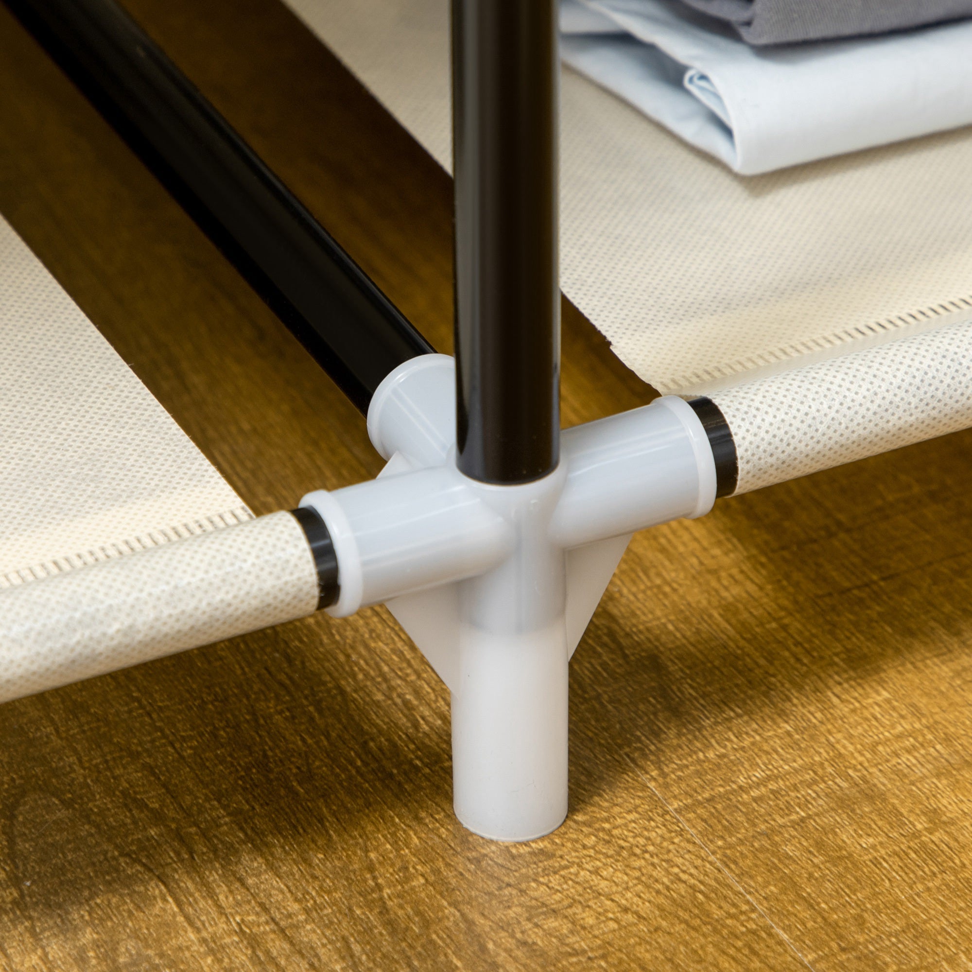 White plastic connector joining powder coated steel frame poles on cream white homcom fabric wardrobe with hanging rail