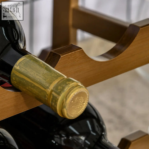 A dark glass wine bottle with golden foil rests in a brown bamboo wine rack with 16 bottle storage for home bar