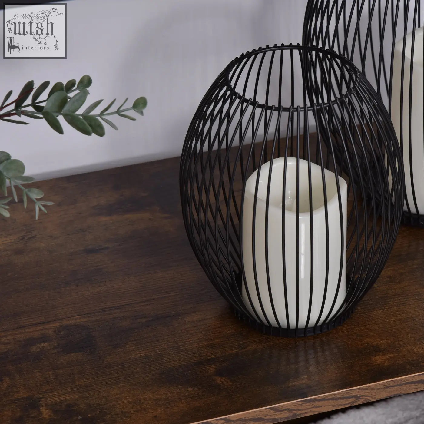Black wire cage lantern with white candle on rustic brown and black homcom industrial bookshelf with open shelves