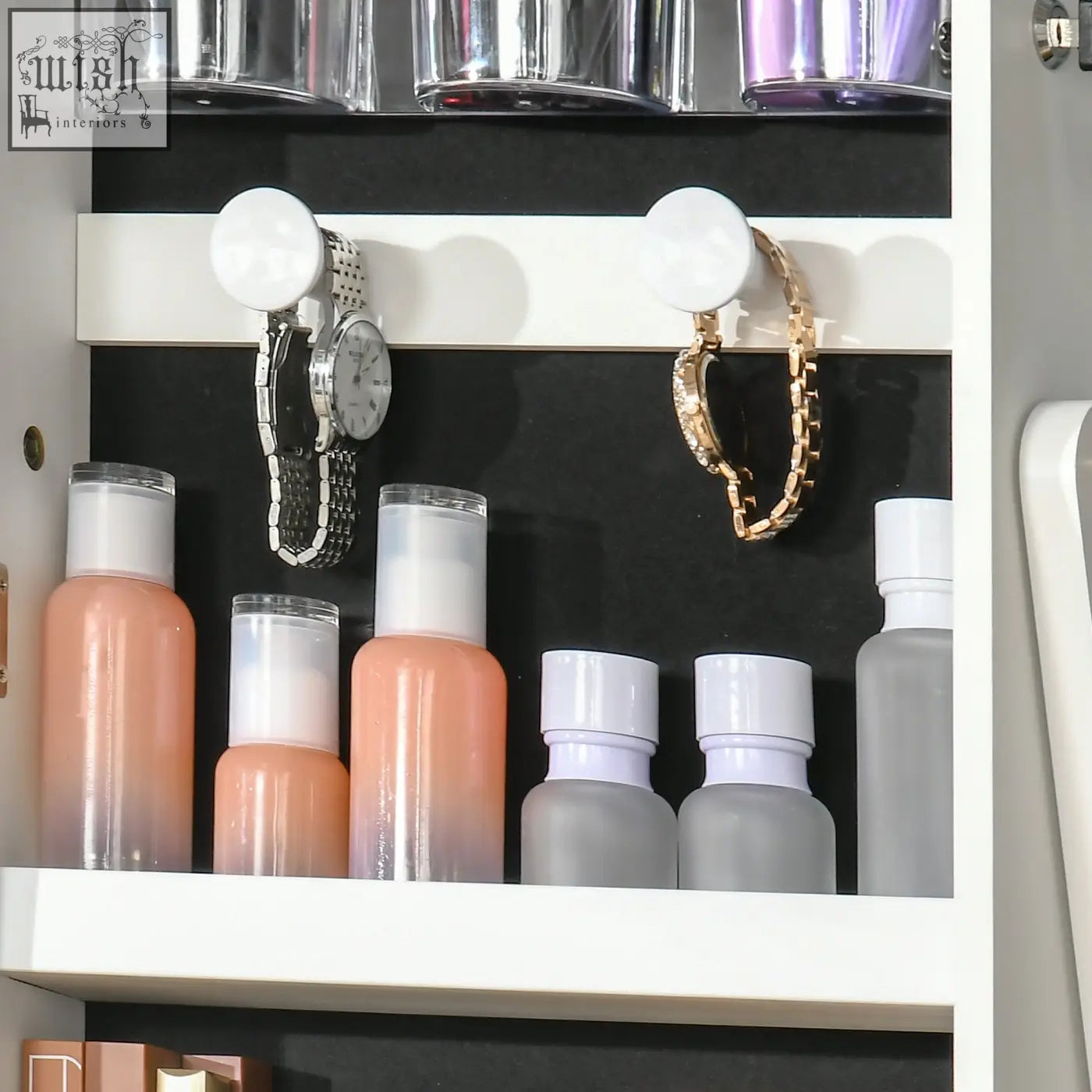 White magnetic hook holding silver watch and gold bracelet inside homcom jewellery cabinet with led light and necklace hooks