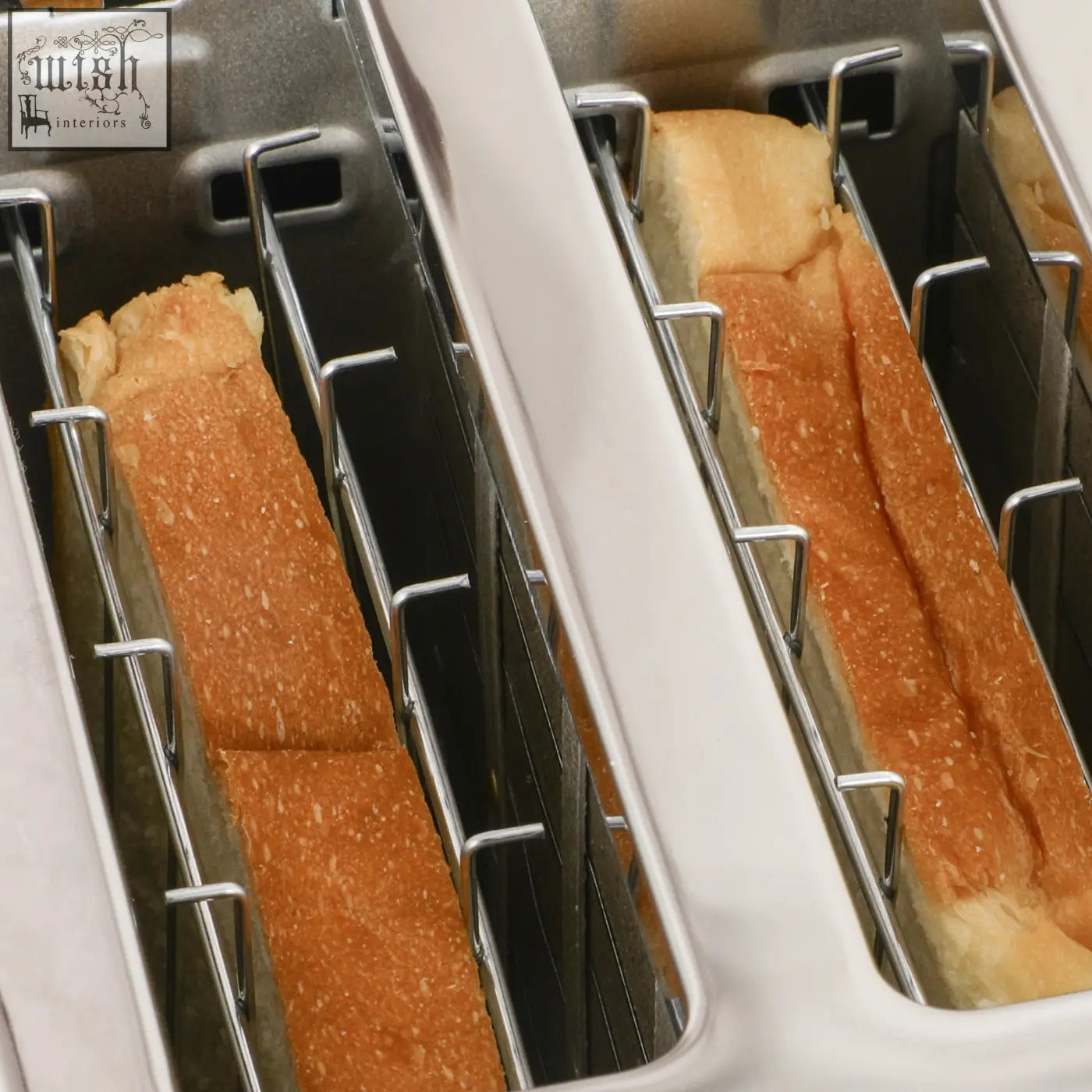Golden brown sliced bread in a white 4 slice toaster with metal slots from homcom rapid boil kettle and toaster set black
