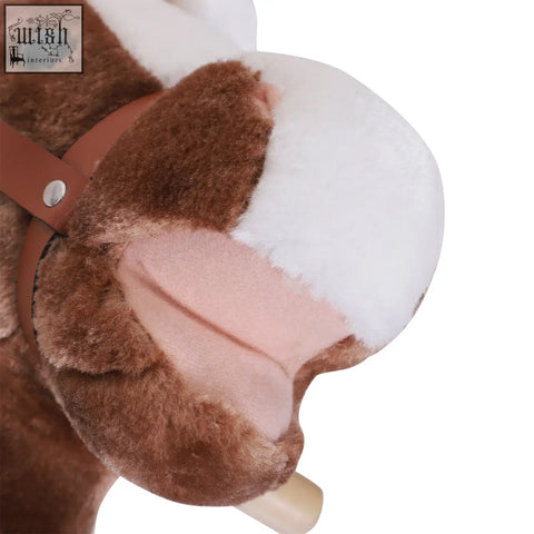 Brown and white plush rocking horse with soft fur pink ears and tan leather strap on wooden base for kids ages 3+