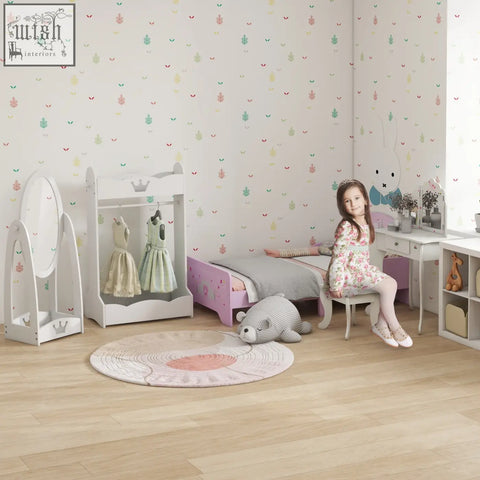 A child sits on a white stool in a pink bedroom with homcom kids clothes wooden clothes rail and storage shelves