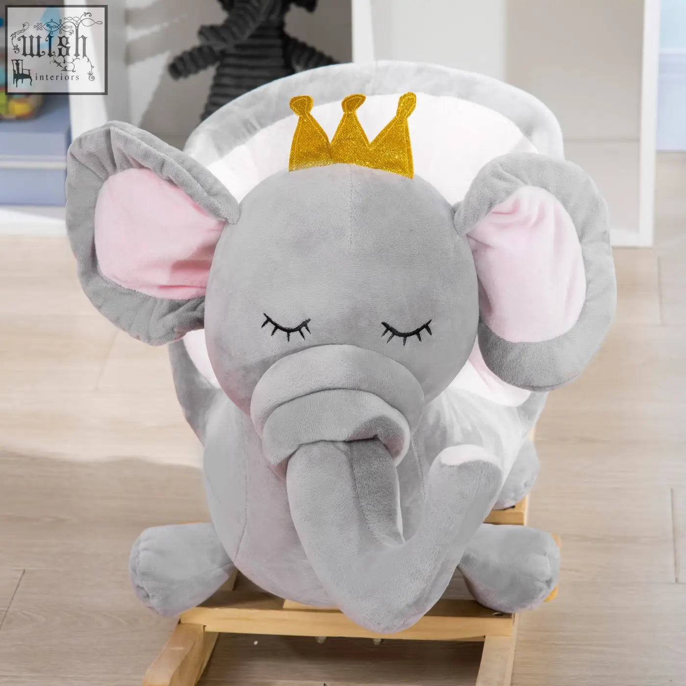 Plush gray elephant rocking horse with pink ears, glittery gold crown, wooden base, safety belt, 60l x 33wcm