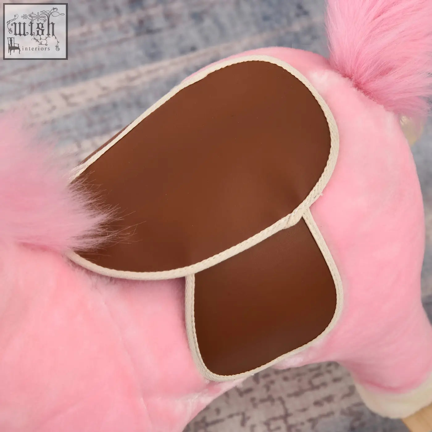 Pink plush rocking horse with brown faux leather saddle cream trim flat seat and ear button for kids 3 to 6 years