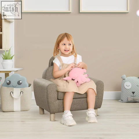 A child sits in a gray linen upholstered homcom kids sofa with padded seat and eucalyptus wood legs