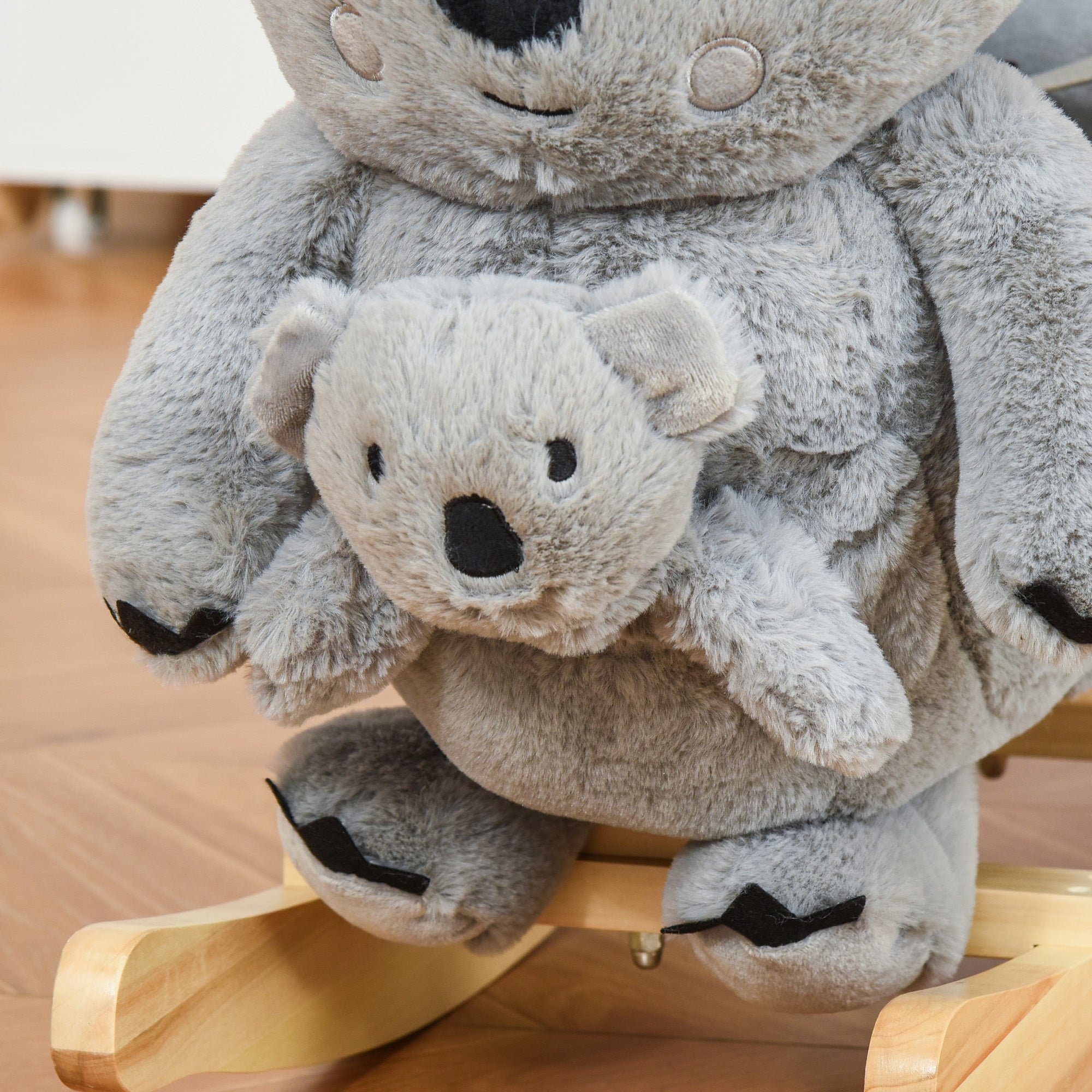 Gray plush koala rocking horse with wooden base and safety belt featuring a smaller koala baby and black paw details