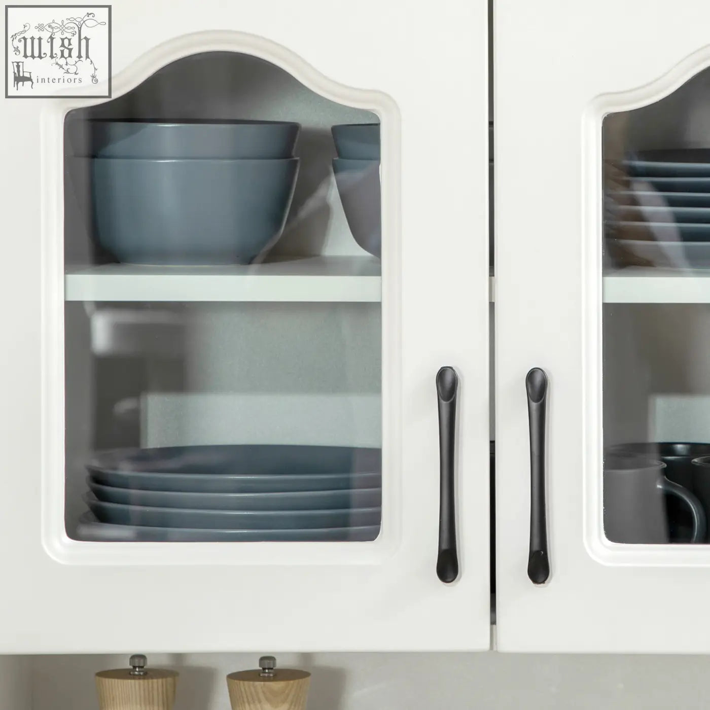 White homcom kitchen cupboard with arched glass doors, two drawers, and gray ceramic bowls inside storage cabinet