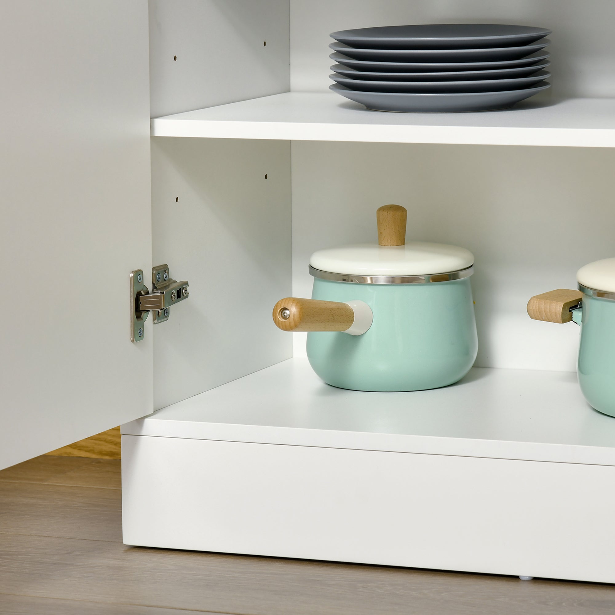 Mint green enamel saucepan with wooden handles on a white homcom kitchen cupboard featuring three open shelves and adjustable shelves
