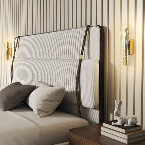 Modern upholstered bed headboard with textured off-white fabric dark metal frame and decorative brown leather straps in living room