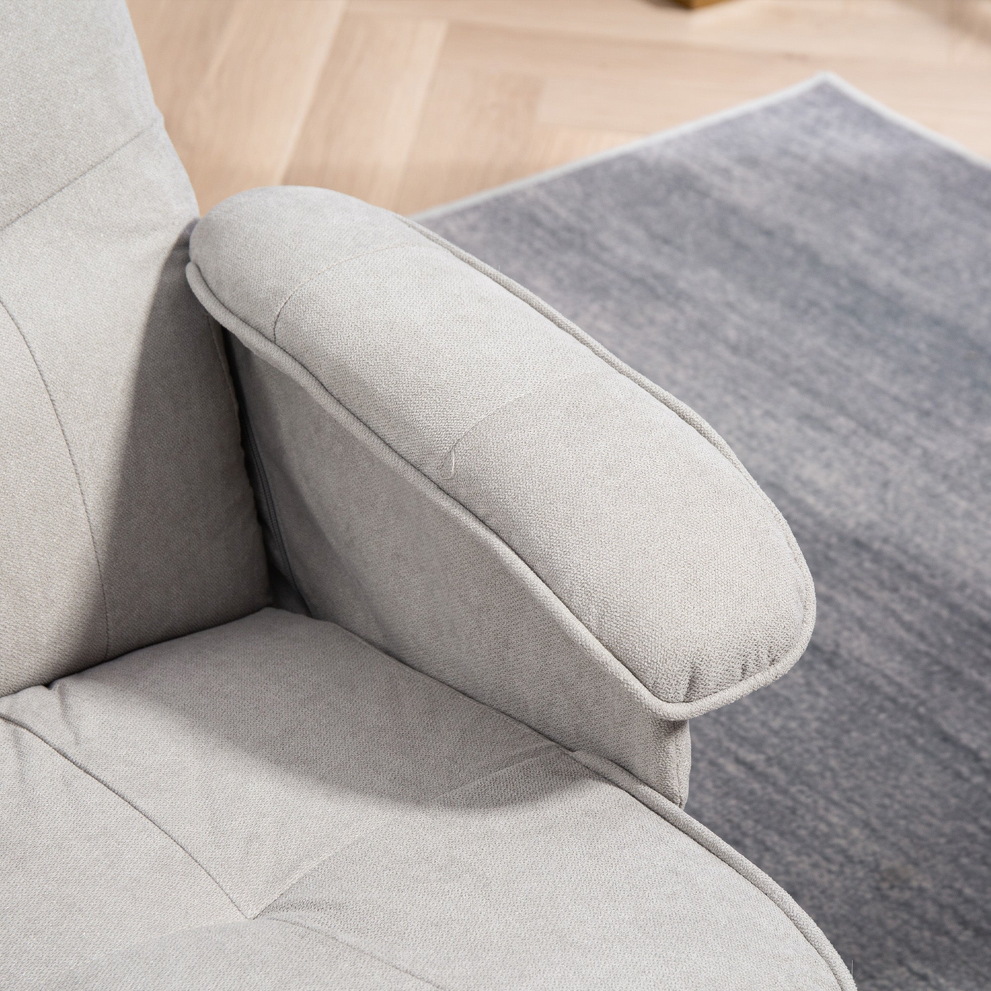 Light gray upholstered armrest of homcom linen-look swivel recliner chair with soft fabric and wooden bases for living room