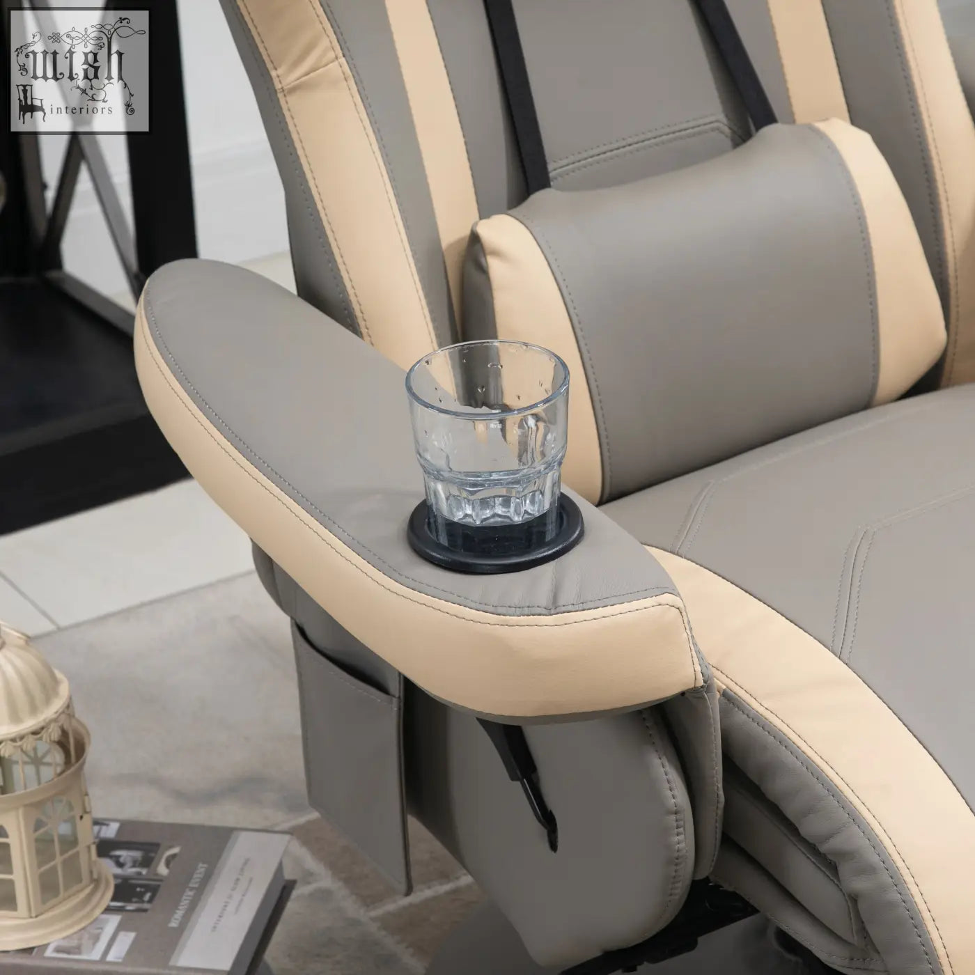 A clear textured glass tumbler on a black coaster next to a grey pu leather recliner chair with 135 c2 b0 reclining and swivel