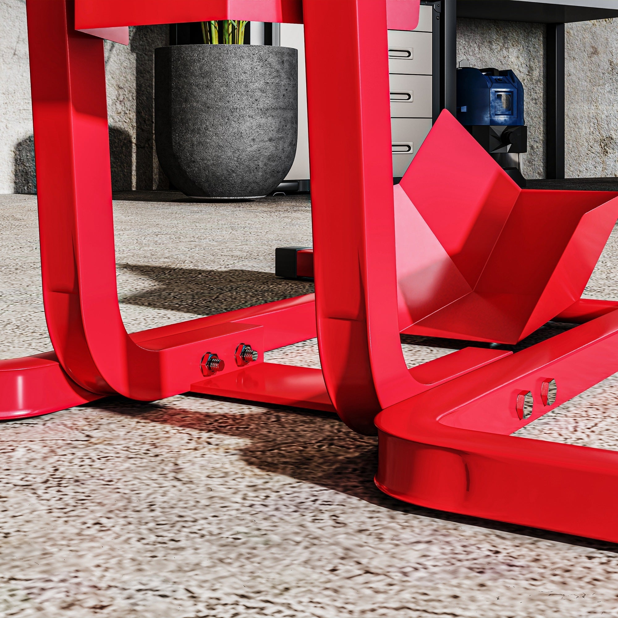 Bright red metal wheel chock with extra strength, angular design, and pre-drilled holes for secure motorbike support