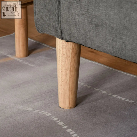 Light oak wooden leg with smooth cylindrical design supporting grey tufted cotton 3 seater sofa with hidden storage