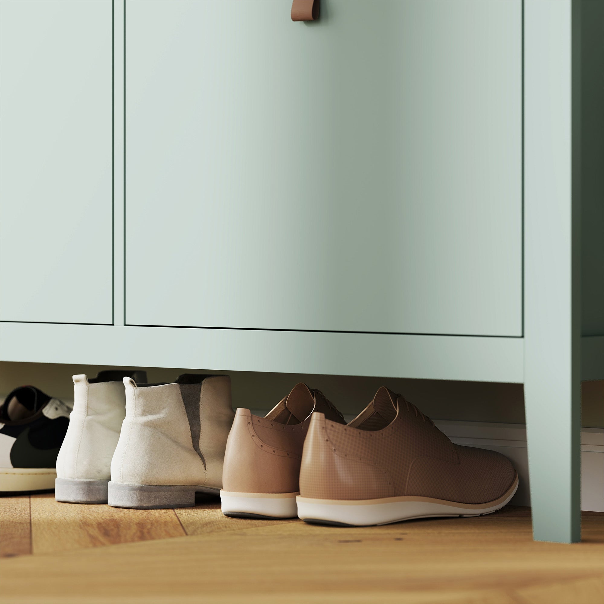 Pair of tan leather slip-on shoes with white sole next to a green homcom modern four-drawer shoe cabinet with four flip drawers