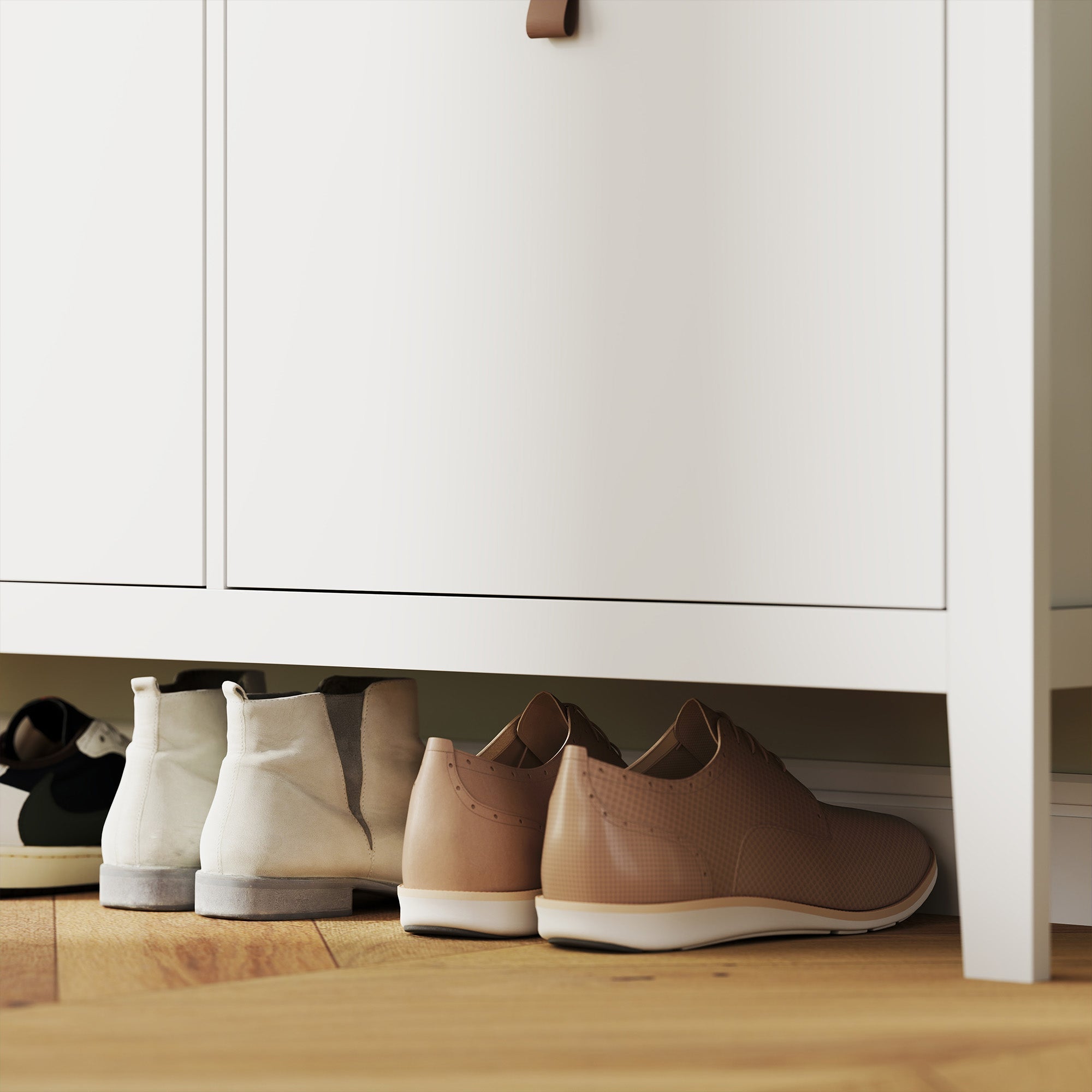 Beige leather lace-up shoes with white soles placed on top of a white homcom modern shoe cabinet with four flip drawers